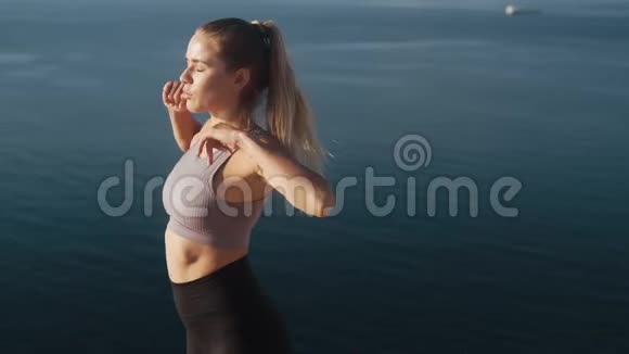 女人在日出时做运动和伸展运动看海慢动作视频的预览图