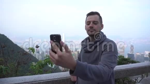 香港的年轻人用智能手机自拍游客正在享受观光和自画像视频的预览图