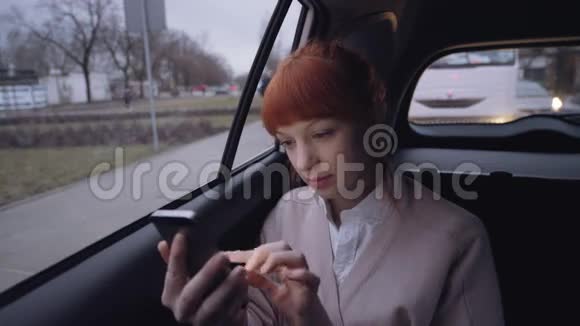 一辆车里的女人用她的手机汽车移动视频的预览图