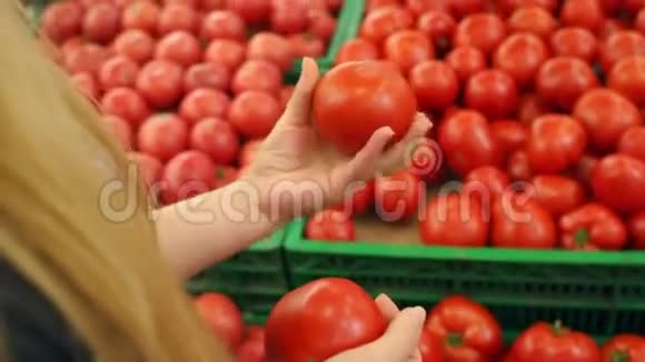 女孩在超市选择西红柿特写视频的预览图