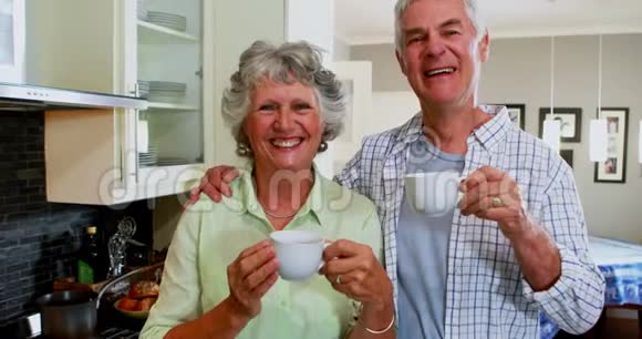 快乐的老夫妻在厨房喝咖啡视频的预览图