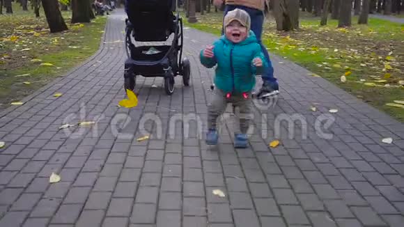 小男孩在公园里迈出第一步秋天的日子视频的预览图