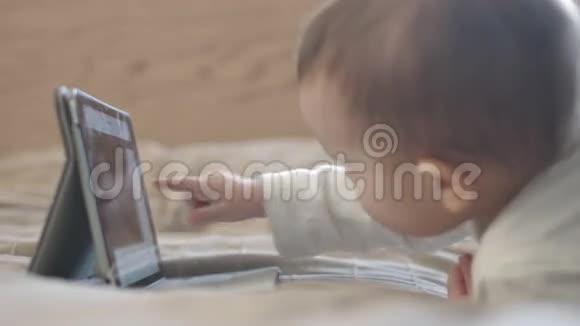小孩子在平板电脑上看动画片视频的预览图