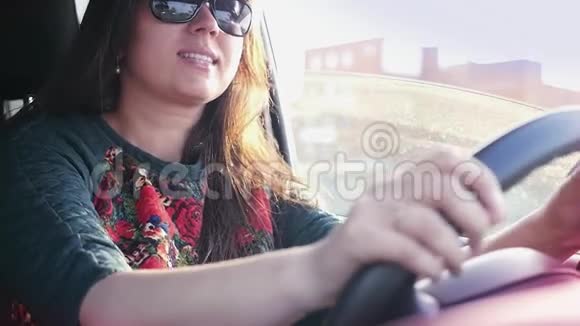 女孩开着车拿着手里的电话看着来电慢动作1920x1080视频的预览图
