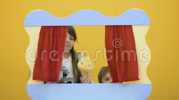 可爱的女孩在木偶戏屏幕后面玩玩具视频的预览图