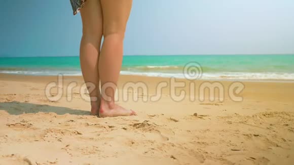 小女孩把衣服扔到沙子上然后去海边中弹视频的预览图
