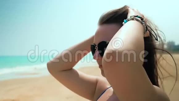 海滩上的年轻女孩调整她的头发近距离射击慢动作视频的预览图