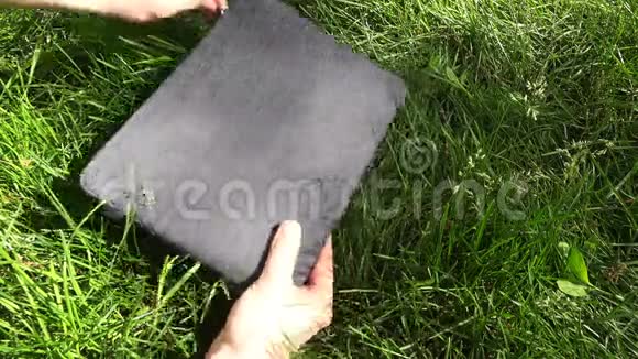 从草地上的盖子上拿出一台白色笔记本电脑视频的预览图
