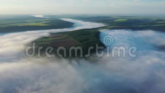 在云层上方的山上鸟瞰田野日出时鸟瞰雾在河上浓雾在河上视频的预览图