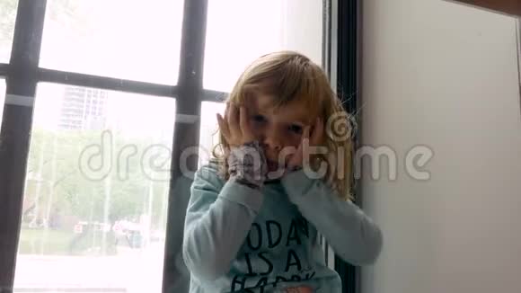 可爱的小女孩在玩她的脸颊视频的预览图