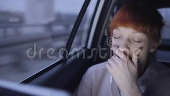 疲惫的女商人坐在车里打哈欠视频的预览图