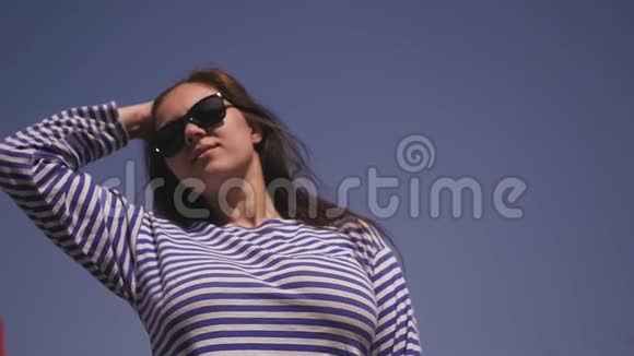 美丽的少女顶着蓝天享受阳光和轻风慢动作1920x1080视频的预览图