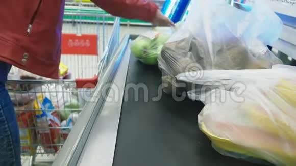 现金在超市一个女人在超市的结账处买杂货4k特写视频的预览图