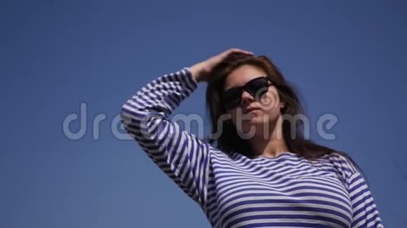 欣赏一个年轻漂亮的女孩穿着条纹衬衫大自然和蓝天慢动作1920x1080高清高清视频的预览图