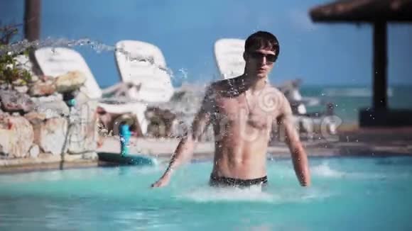 年轻的帅哥戴着太阳镜在游泳池水下放松度假旅行视频的预览图