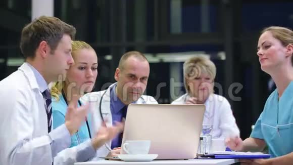 一组医生在会议室讨论笔记本电脑视频的预览图