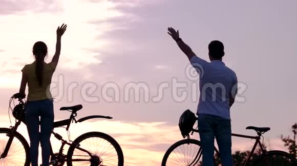 日落时骑自行车的年轻朋友视频的预览图
