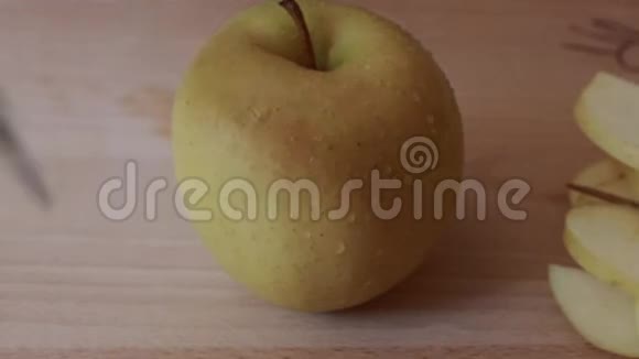 女人用刀把苹果切成薄片放在厨房的桌子上的切割板上视频的预览图