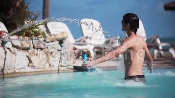 阳光明媚的一天年轻的帅哥戴着太阳镜在游泳池的溪水下放松在旅行度假视频的预览图