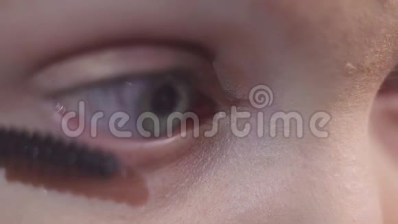 绿眼女人用黑色化妆品涂睫毛膏视频的预览图