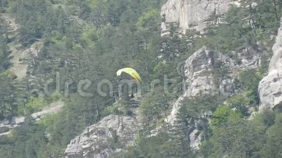 黄色滑翔伞在绿油油的克里米亚山脉背景下飞翔视频的预览图