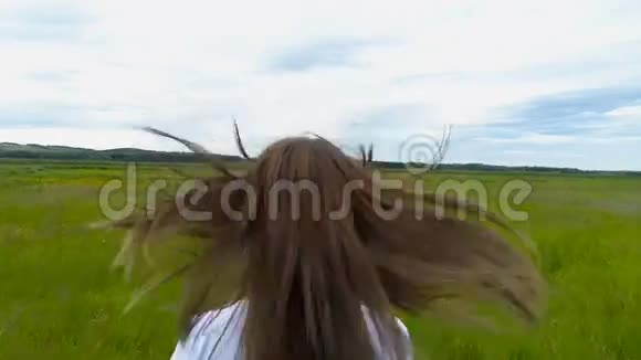 美丽的黑发女孩跑过田野慢镜头拍摄视频的预览图