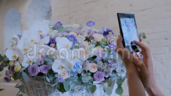 女人用智能手机拍大花篮视频的预览图