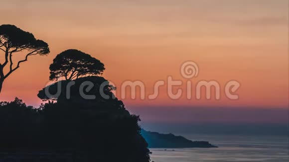 时间流逝美丽的夕阳落在意大利索伦托的意大利山上的树木后面视频的预览图