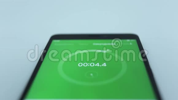 用白色运行数字的数字秒表的绿色特写智能手机上的秒表视频的预览图
