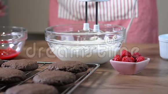 将奶油与马达搅拌器混合在碗中奶油中加入覆盆子酱视频的预览图