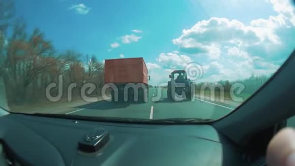 汽车在卡车前面拖拉机沿着道路行驶驾驶舱内的道路慢动作录像视频的预览图