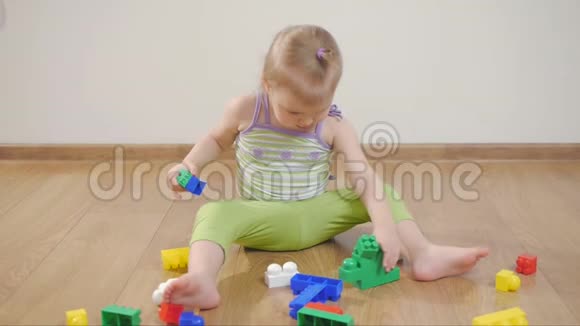 小女孩在彩色积木里玩耍坐在白色的背景上孩子和玩具视频的预览图