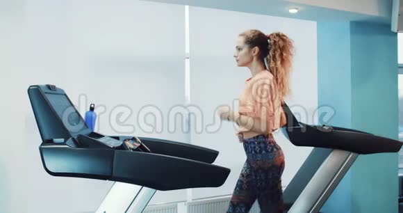 运动健身馆里跑步的漂亮女孩视频的预览图