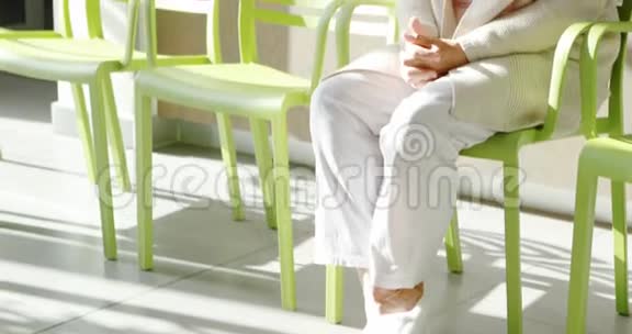 体贴的高级妇女坐在大厅的椅子上视频的预览图