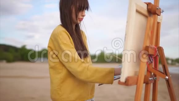 一个年轻的女人在露天画架上画一支画笔画架上画着一个静物视频的预览图