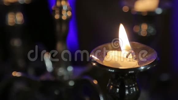 一支蜡烛放在桌子上的黑色背景外套上视频的预览图