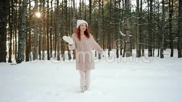 冻僵的女孩在冬天的森林里美丽的模特跳跃跳舞女孩试图温暖活跃的动作冬天的自然视频的预览图