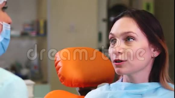 牙科柜里的快乐女病人病人和牙医之间的谈话视频的预览图