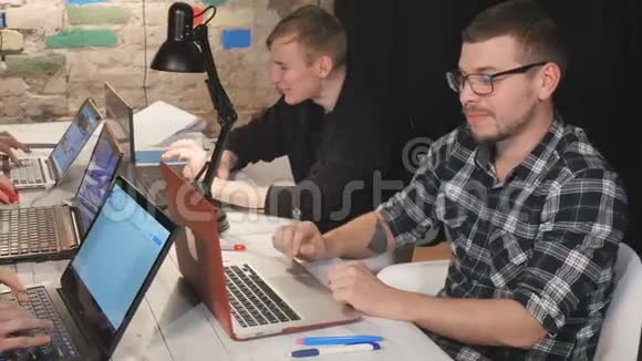 人们在办公室的桌子上用笔记本电脑工作视频的预览图