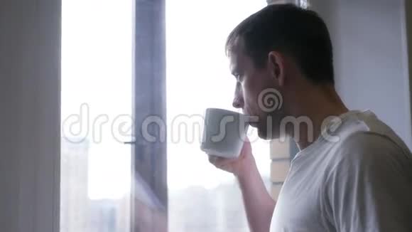 一个年轻开朗的人喝白杯子茶或咖啡4K3840x2160高清高清视频的预览图