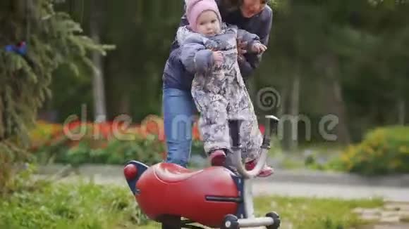 幸福的家庭父亲母亲和孩子在秋天公园散步的小女孩妈妈和宝宝在操场玩耍视频的预览图