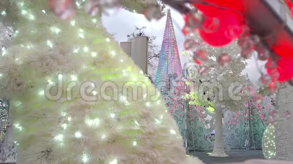 圣诞彩灯装饰了小镇上的人造圣诞树白树和大型动物视频的预览图