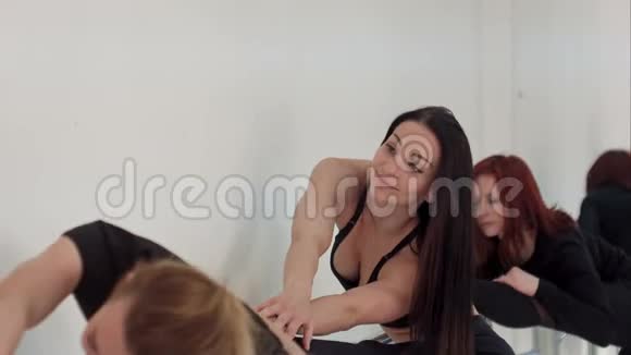 一群年轻女性在教室里的酒吧和镜子附近伸展视频的预览图