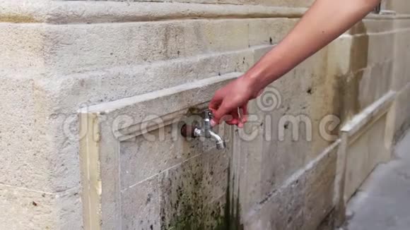 那个人把水龙头开在墙上巴库街市饮用喷泉视频的预览图