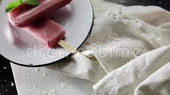 合上草莓冰淇淋缓慢的食物运动两根棍子在黑色的木制背景板上在炎热的夏天帮忙视频的预览图