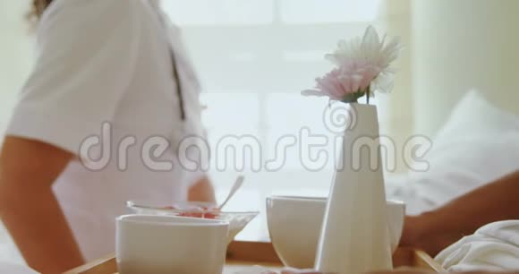 女医生为4k床的老年妇女提供早餐视频的预览图