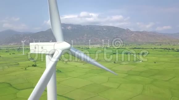 风车涡轮对蓝天和山体景观清洁可再生能源航拍用风力发电机医生视频的预览图