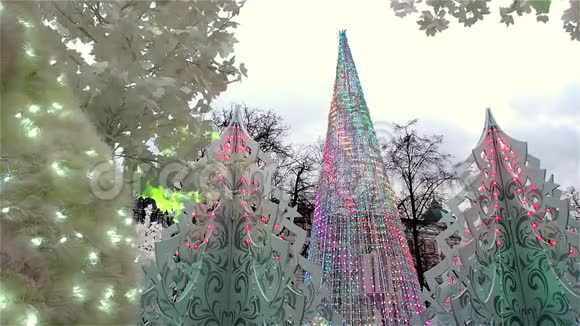 圣诞彩灯装饰了小镇上的人造圣诞树白树和大型动物视频的预览图