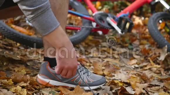 在公园里系鞋的活跃的健康人士慢动作视频的预览图