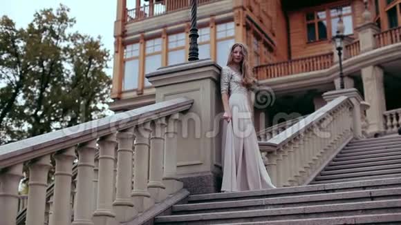 女孩站在宫殿背景下的一个大石头楼梯上视频的预览图